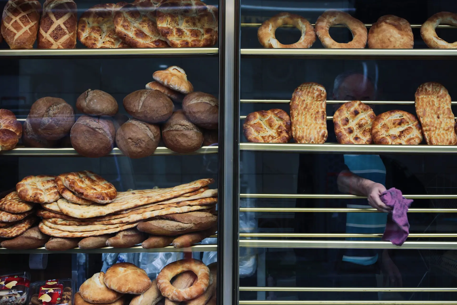 A diverse assortment of baked breads displayed in a bakery window in Istanbul, Turkey.